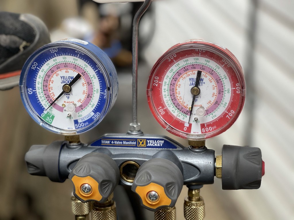 Refrigeration manifold gauges checking system charge during a heat pump service
